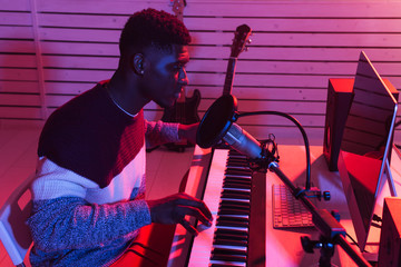 Musician and making music concept - African american male sound producer working in recording...