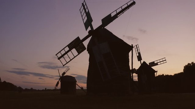 Field of historical windmills while twilight. Night in the village.