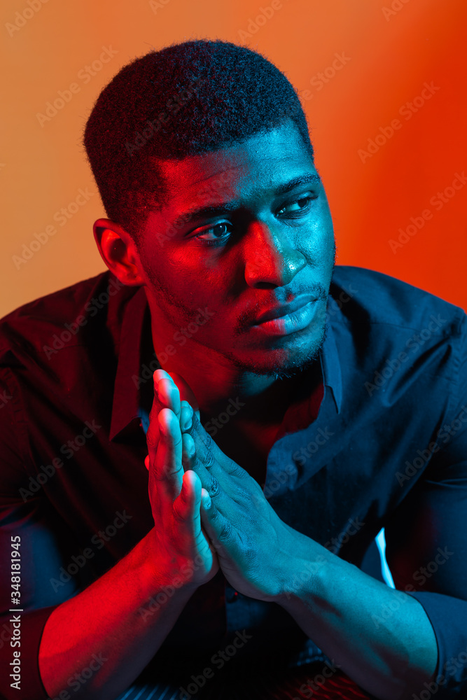 Wall mural face african american stylish man posing on the blue and red neon light background.