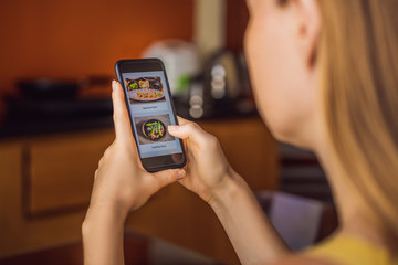 Young woman orders food for lunch online using a smartphone