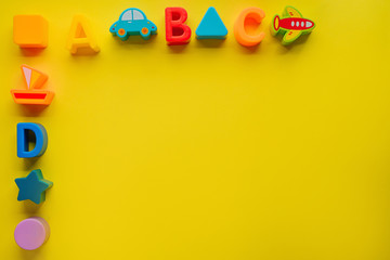 Top view on children s toys on a yellow background. Children's toys on the table. concept for advertising toys for children. Copy space children's toy.