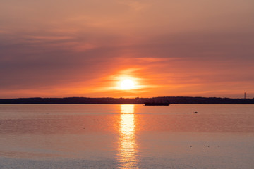 Obraz premium Beautiful red orange sunset with reflection over Oresund and the island of Ven. Photo taken from Glumslovs backar in Glumslov, Sweden.