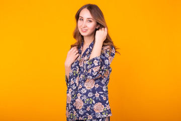 Obraz premium Fashion portrait pretty cool girl in home wear pajama having fun over colorful yellow background.