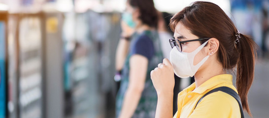 Fototapeta na wymiar young Asian woman wearing protection face mask prevent coronavirus or Corona Virus Disease (Covid-19) at public train station. Infection and Pandemic concept