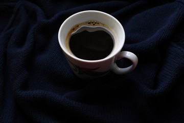 a Cup of coffee, in a white Cup on a dark blue plaid