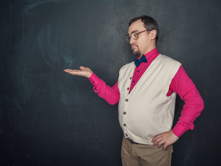 Funny vintage style man looking on something on his hand on blackboard