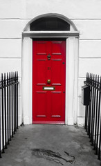 The Victorian house's door.
Colorful picture of a red front door  of a Victorian traditional house in a wealthy neighborhood Of London.