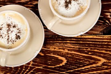 cups with coffee and milk foam sprinkled with dark chocolate