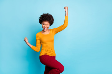 Portrait of crazy delighted afro american girl celebrate lottery victory feel lucky raise fists...