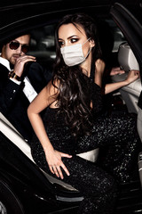 Fototapeta na wymiar Couple in face mask in the car. Hollywood stars.