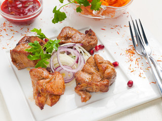 pork skewers with pickled onions on a white plate