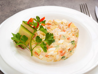 traditional Russian salad with chicken on a white plate