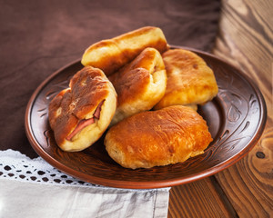 Food at home. Close-up of patty with sausages on a ceramic brown plate