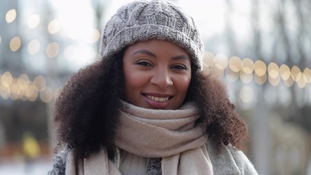 portrait of middle aged woman outside in winter in scarf and hat. spbi female smiling giving look at camera, pose for photo shoot. concept happiness, mixed race pretty