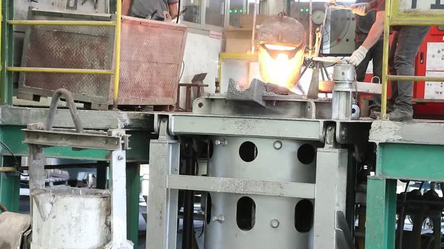 operator pour molten metal from ladle  into induction furnace