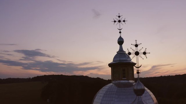Decorative crosses of historical village church. Twilight evening sky on background.