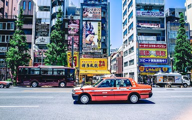Plakat Vehicles On Road Against Buildings In City