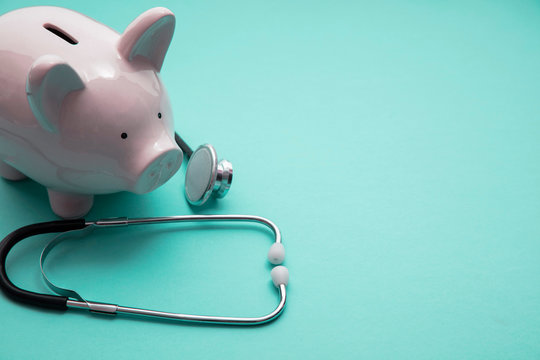 Cost of healthcare. Piggy bank money box with a medical doctors stethoscope