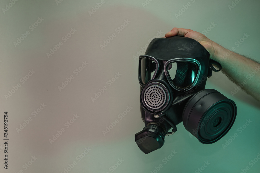 Poster Hand hold black old gas mask in the color light. Beautiful old minimal in neon light. Minimalism retro style concept. Background pattern for design.