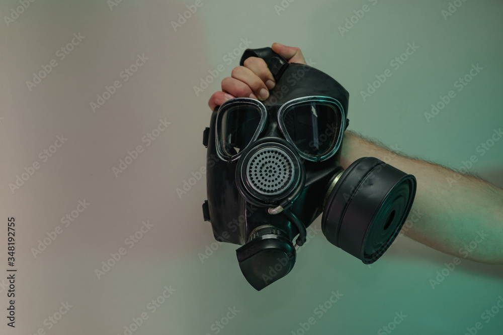 Poster Hand hold black old gas mask in the color light. Beautiful old minimal in neon light. Minimalism retro style concept. Background pattern for design.