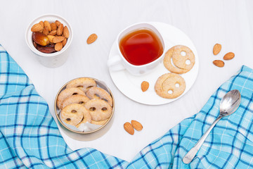 Homemade smile cookies with cup of black tea on white wooden background. Good morning or have a nice day concept. Flat lay.