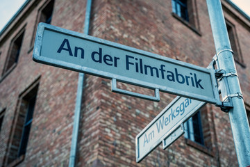 street sign in German Filmfabrik meaning Film Factory located in historical area still used to film movies and television shows