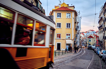 Old tram moves through the historic district in Lisbon.