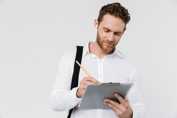 Image of smiling man in earphones holding clipboard and writing