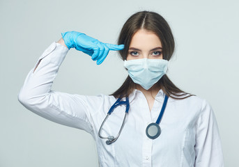 Covid19, coronavirus, a concept of healthcare and doctors. Portrait of a female doctor who shows a stop gesture! puts on a medical mask to prevent infection with the virus