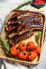 Delicious barbecued ribs seasoned with a spicy basting sauce and served with baked tomatoes. Gray...