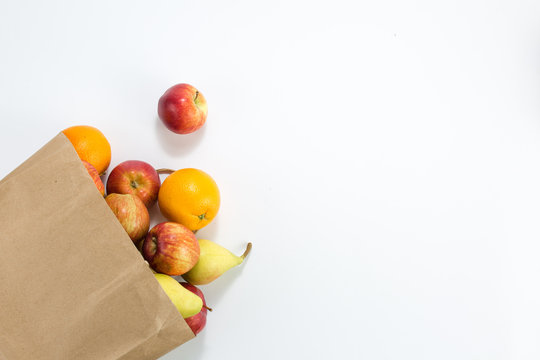 Apples And Pears In A Paper Bag Of Craft Paper On White Background. Free Space For Your Text. Top View.