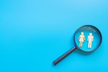 Employee search HR concept - magnifier with abstract employee on a blue background. Close up.