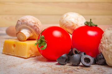 homemade pizza ingredients tomatoes, champignons, cheese, olives and dough