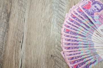 a lot of hryvnia on a wooden background. Copy space. Place for text. View from above. 200 hryvnias fan on the table.