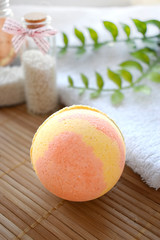 Still life spa resort treatment with bath bomb and towel on wooden background. Natural aromatherapy and relax concept.