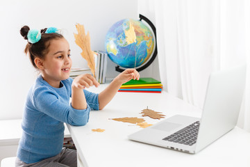 little girl studying nerd on laptop online