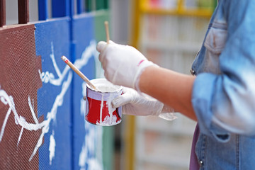 A photo of artist painted on the metal gate. Focus on the  paint can.