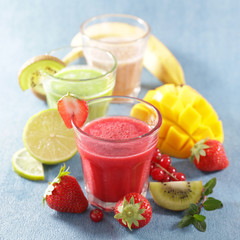 smoothie with fresh fruits on blue background