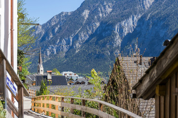 View of the mountains and the Hallstatt Lake looking through between the traditional houses of Hallstatt, Austria