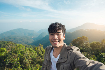 Naklejka premium Asian man traveller happy smiling take a selfie on the mountain.