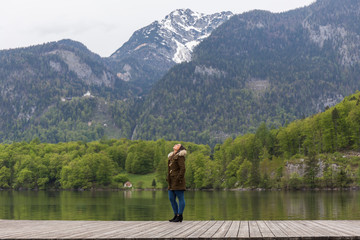 woman on a wooden jetty by the lake in austrian tyrol on a cold and rainy day