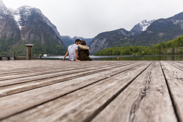 wooden texture of a jetty, in the background couple sitting