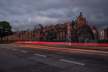 Fototapeta premium road in front of the storage city in hamburg with traffic lanes with an iron bridge in the foreground