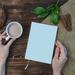 Mockup Flat lay composition with book, hand , cup of coffee on wooden table eco concept Copyspace