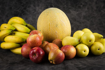 fruits cabbage banana melon grape orange apples pear a dark background. health vegetarianism