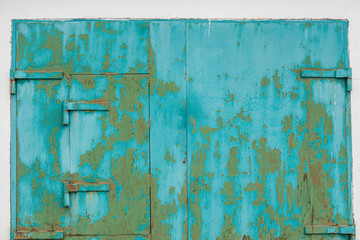 Teal painted scratched old metallic garage door