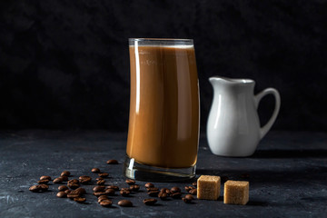 Ice coffee frappe in tall glass. Cool summer drink on a dark background in low key. Close up, copy...