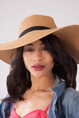 Thoughtful woman in a straw hat and blue jean jacket