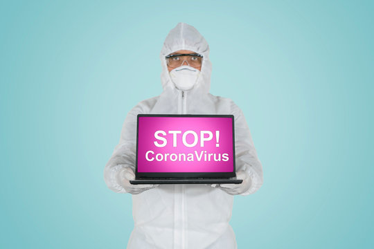 Doctor showing text of stop coronavirus on laptop