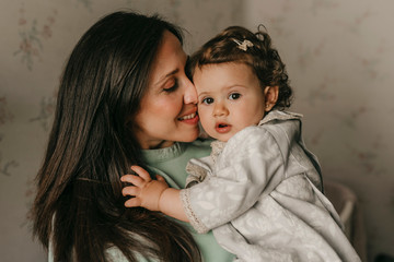 pretty young mother with her little daughter in the room